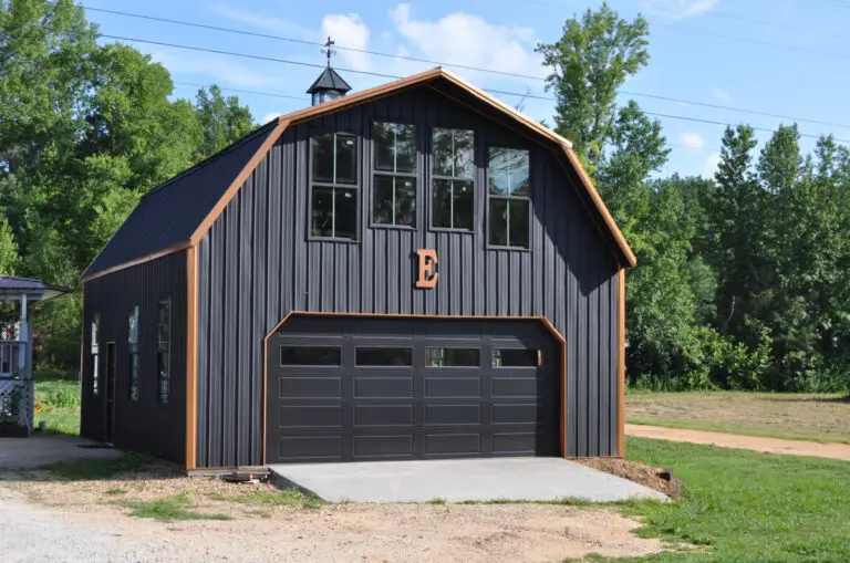 Black gambrel-roof garage with a cupola and two garage doors