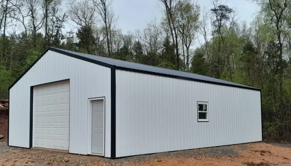 Side of the 30 x 40 x 12 garage, white siding with black trim and a walk door