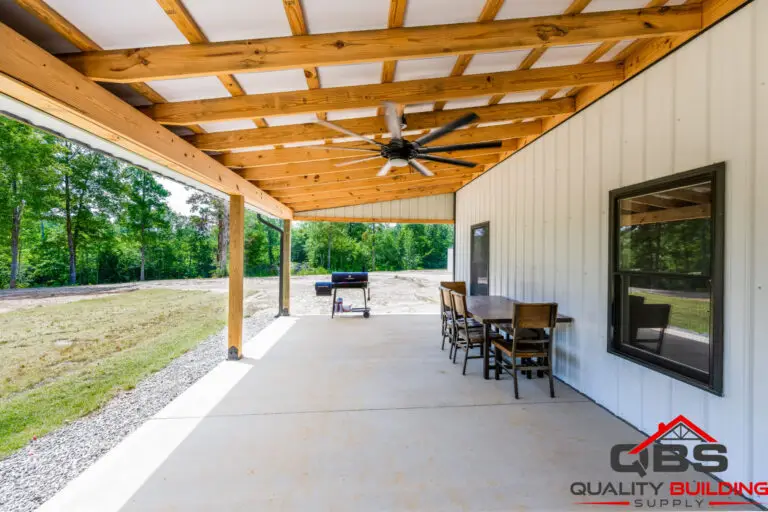 Smith barndominium covered patio with ceiling fans and dining table