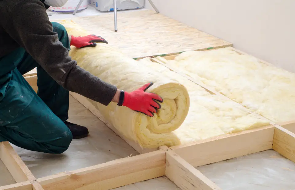 Installer rolling out insulation between studs