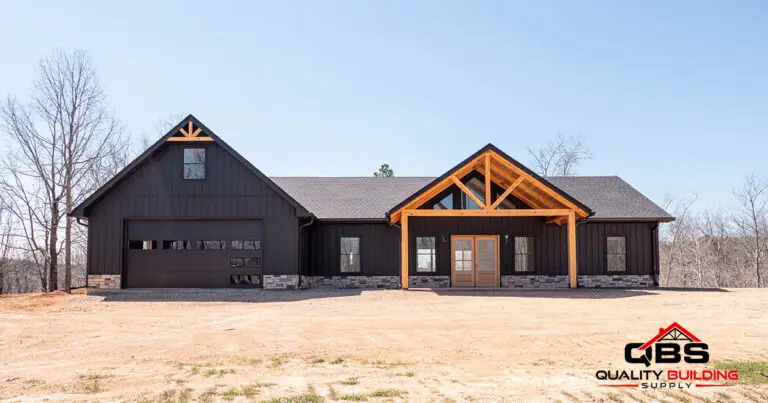 The Cypress Ridge barndominium, black barndominium with a timber gable porch