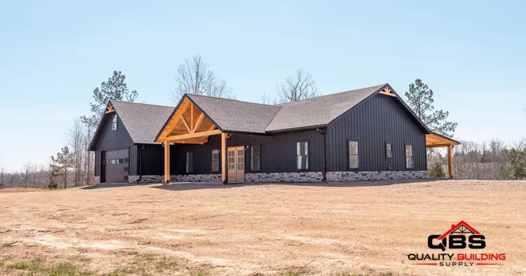 The Cypress Ridge barndominium, black board-and-batten with timber gable porches