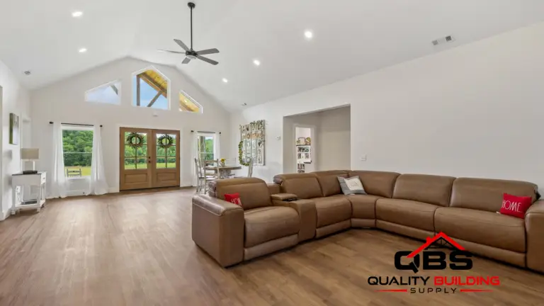 Living room with a vaulted ceiling and leather sectional in the Cypress Ridge barndominium