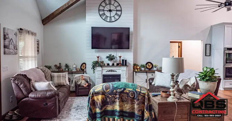 Living room with a vaulted ceiling and fireplace in the White Oak barndominium