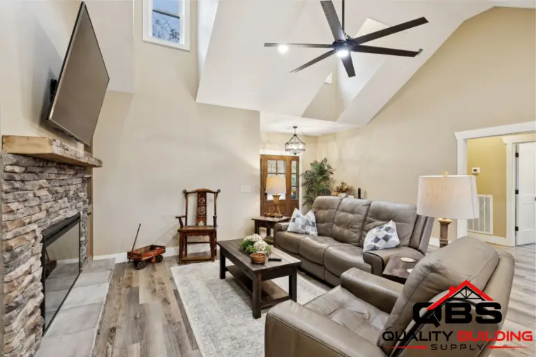 Living room with a vaulted ceiling and stone fireplace in the Oak Grove barndominium