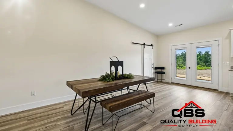 Dining area with a wood table and bench in the Smith V2 barndominium