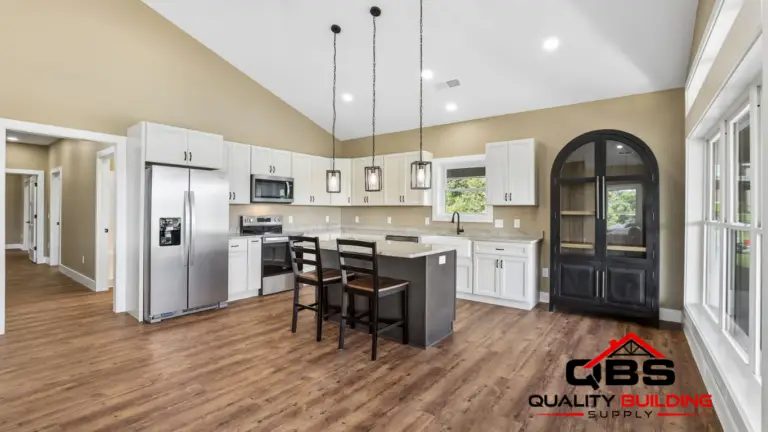 Kitchen with white cabinets and an arched front door in the Shady Grove barndominium