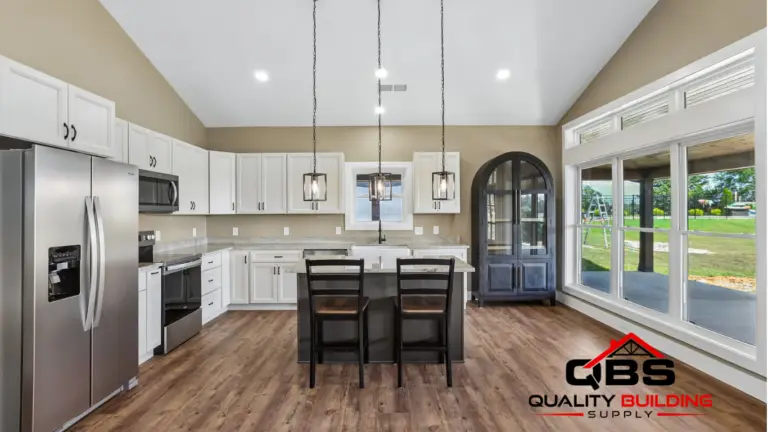 Kitchen with white cabinets and an arched door in the Shady Grove barndominium